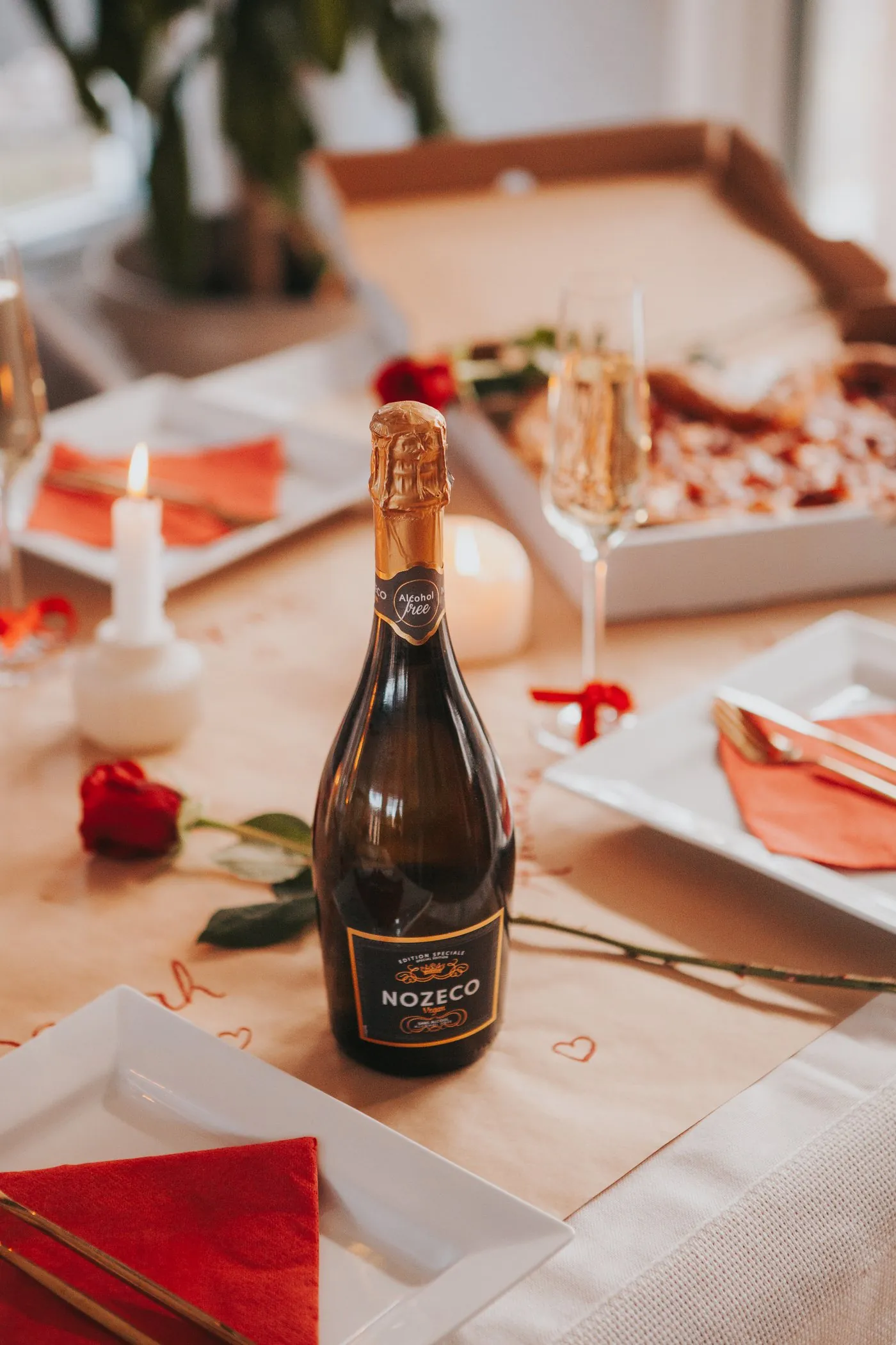 Bouteille de Nozeco sur une table dressée avec des roses